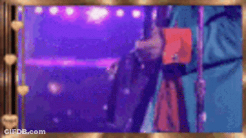 A Person Is Standing In Front Of A Microphone On A Stage Holding A Book . GIF