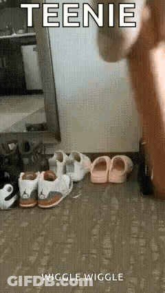 A Person Is Standing In Front Of A Mirror Next To A Row Of Shoes . GIF