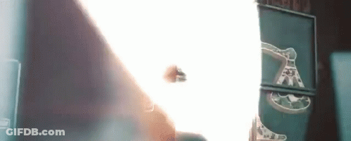 A Person Is Standing In Front Of A Wall With A Light Coming Through It . GIF
