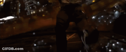 A Person Is Standing In Front Of A Window In A Dark Room With A Candle . GIF