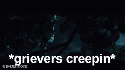 A Person Is Standing In The Dark With The Words `` Grievers Creepin '' Written Above Them . GIF