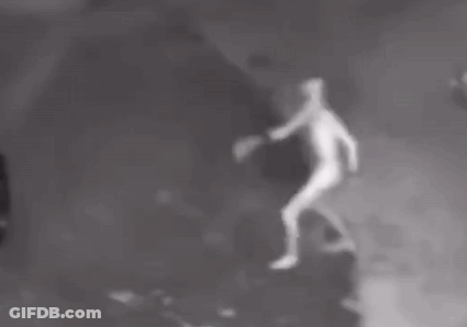 A Person Is Standing In The Dark With Their Arms Outstretched In A Black And White Photo . GIF