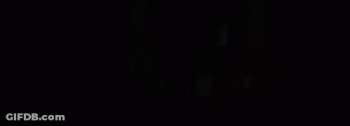 A Person Is Standing On A Bed In A Dark Room With Smoke Coming Out Of The Window . GIF