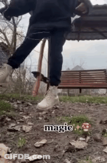 A Person Is Standing On A Dirt Path In Front Of A Park Bench . GIF