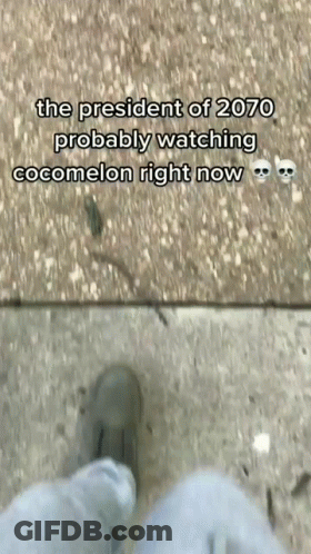 A Person Is Standing On A Sidewalk With A Caption That Says The President Of 2070 Probably Watching Cocomelon Right Now GIF