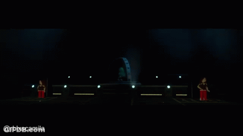 A Person Is Standing On A Stage With A Globe In The Background GIF