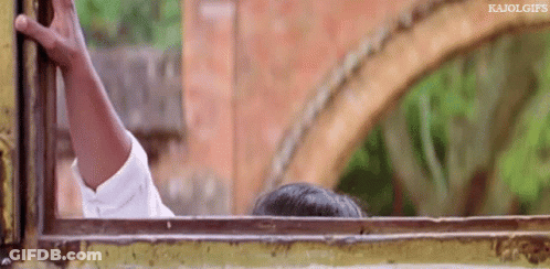 A Person Is Sticking Their Head Out Of A Window With A Brick Wall In The Background . GIF