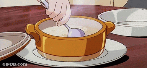 A Person Is Stirring A Bowl Of Soup With A Spoon On A Table . GIF