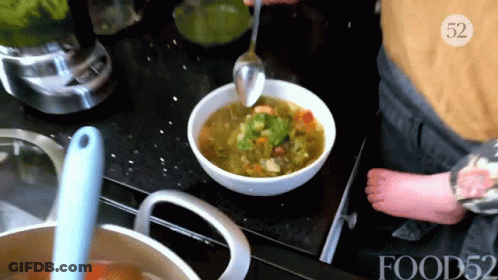 A Person Is Stirring A Bowl Of Soup With A Spoon With The Number 52 On The Bottom GIF