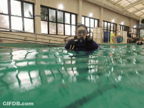 A Person Is Swimming In A Pool With A Scuba Diving Mask On GIF