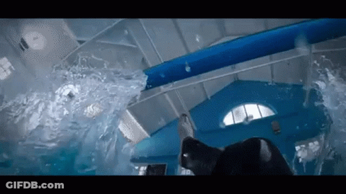 A Person Is Swimming In A Pool With A Water Slide . GIF