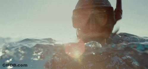 A Person Is Swimming In The Ocean Wearing A Mask And Goggles GIF