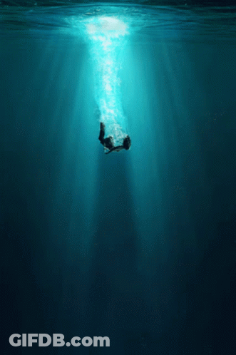 A Person Is Swimming In The Ocean With The Sun Shining Through GIF