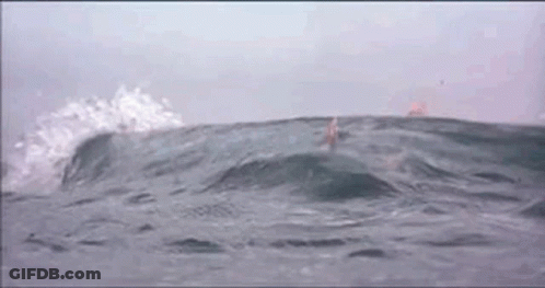 A Person Is Swimming In The Ocean With Waves Crashing Against Them GIF