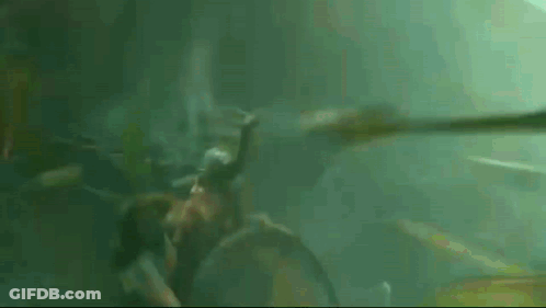 A Person Is Swimming In The Water With A Snake In Their Mouth . GIF