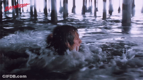 A Person Is Swimming Under A Pier And The Word Baywatch Is Visible GIF