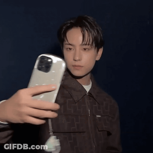 A Person Is Taking A Picture Of A Man With A Phone GIF