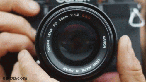 A Person Is Taking A Picture With A Canon Lens Made In Japan GIF