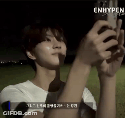 A Person Is Taking A Picture With A Cell Phone And The Word Enhypen Is On The Bottom GIF
