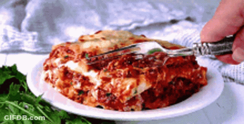 A Person Is Taking A Piece Of Lasagna With A Fork . GIF