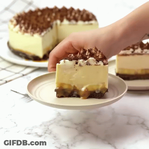 A Person Is Taking A Slice Of Cake From A Plate GIF