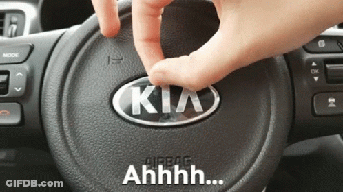 A Person Is Touching A Kia Logo On The Steering Wheel GIF