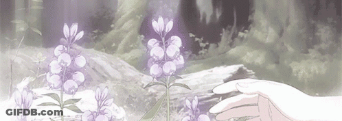 A Person Is Touching A Purple Flower In A Field . GIF