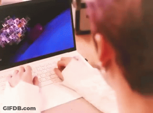 A Person Is Typing On A Laptop Computer While Sitting At A Desk . GIF