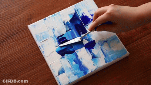 A Person Is Using A Palette Knife To Spread Blue Paint On A Canvas GIF