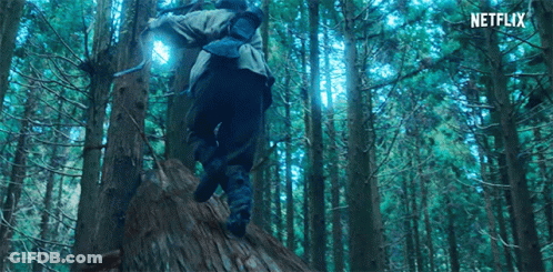 A Person Is Walking Through A Forest With A Backpack And A Light On Their Back . GIF