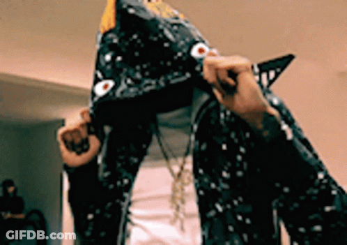 A Person Is Wearing A Hoodie That Looks Like A Shark 'S Head . GIF