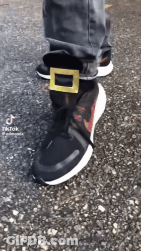 A Person Is Wearing A Pair Of Black Nike Shoes GIF