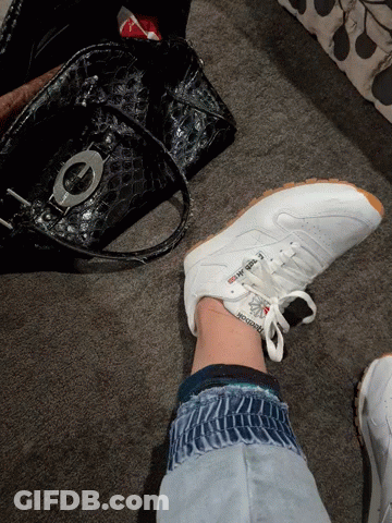 A Person Is Wearing A Pair Of White Reebok Sneakers GIF