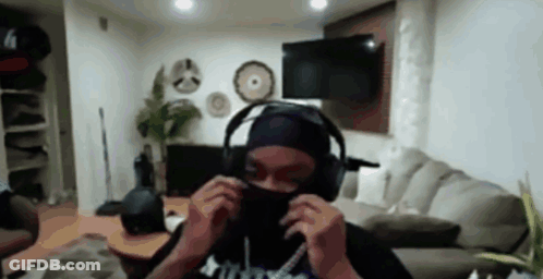 A Person Is Wearing Headphones And A Mask In A Living Room . GIF