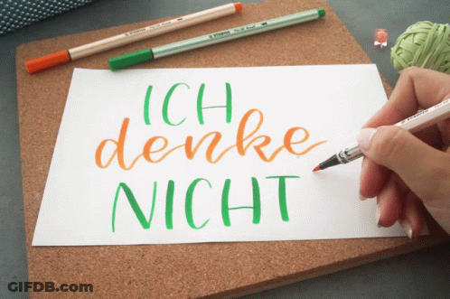 A Person Is Writing Ich Denke Nicht On A Piece Of Paper With A Brush GIF