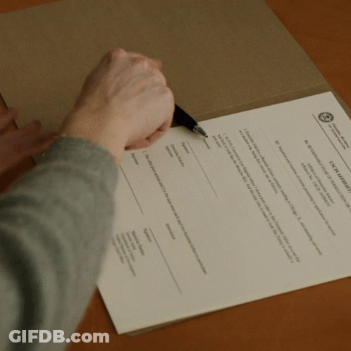 A Person Is Writing On A Piece Of Paper That Says " A Declaration Of Independence " On It GIF
