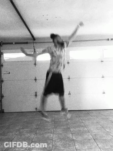 A Person Jumping In The Air In A Garage GIF