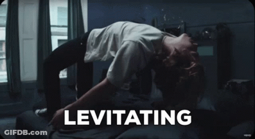 A Person Laying On A Bed With The Word Levitating Written Above Them GIF