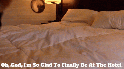A Person Laying On A Bed With The Words Oh God I 'M So Glad To Finally Be At The Hotel Below Them GIF