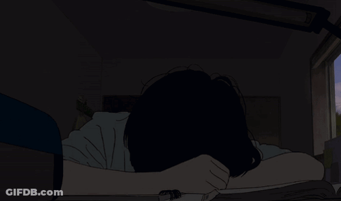 A Person Laying On A Bed With Their Head In Their Hands In The Dark GIF