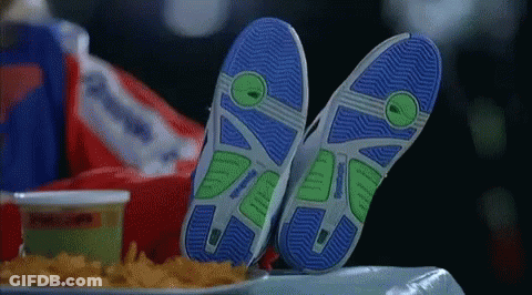 A Person Laying On A Table With Their Feet Up And A Tray Of French Fries . GIF