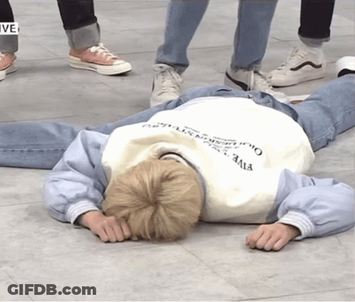 A Person Laying On The Floor Wearing A Sweatshirt That Says Five On It GIF