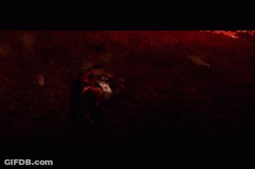 A Person Laying On The Ground In A Dark Room GIF