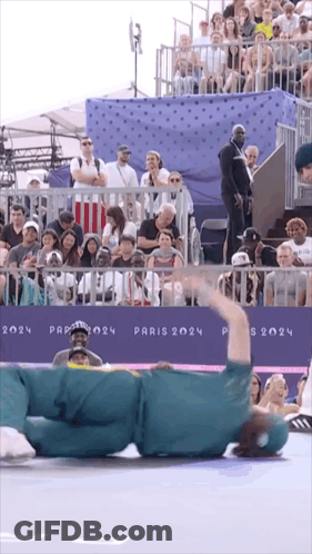 A Person Laying On The Ground In Front Of A Sign That Says " Paris 2024 " GIF