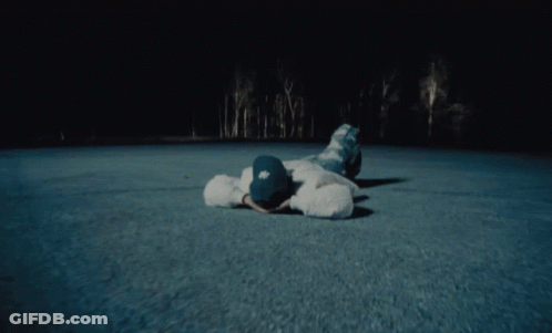 A Person Laying On The Ground Wearing A Hat With Ny On It GIF