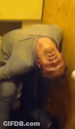 A Person Laying On Their Back With Their Head On A Table GIF