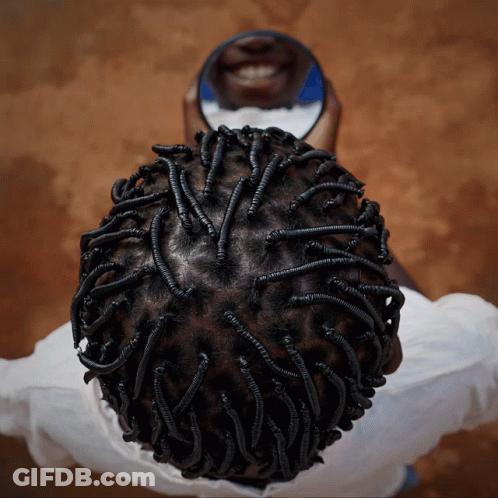 A Person Looking At Their Hair In A Mirror And Smiling GIF