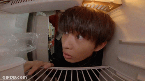 A Person Looking Into A Refrigerator With The Website Dryedmangoes.com Visible GIF