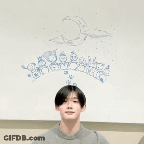 A Person Making A Heart With Their Hands In Front Of A Drawing Of Snowmen And A Crescent Moon GIF