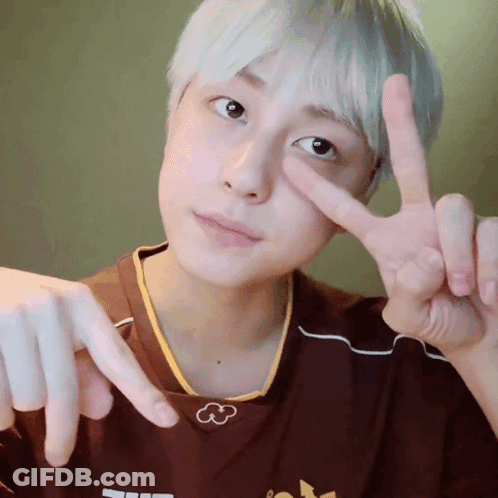A Person Making A Peace Sign With Their Fingers In Front Of Their Face GIF